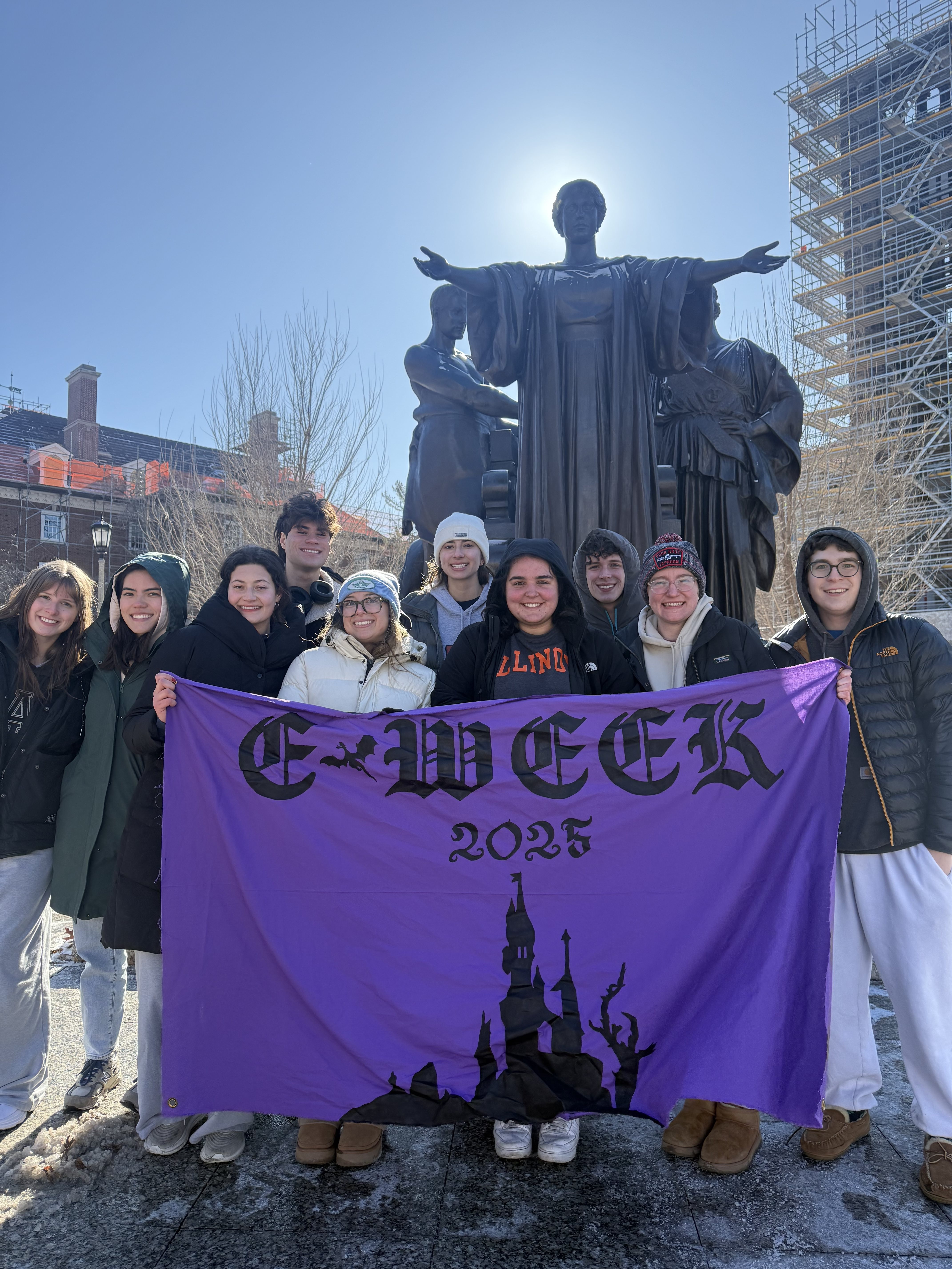 The Theta Tau E-Week team holding the E-week banner in front of Alma Mater.