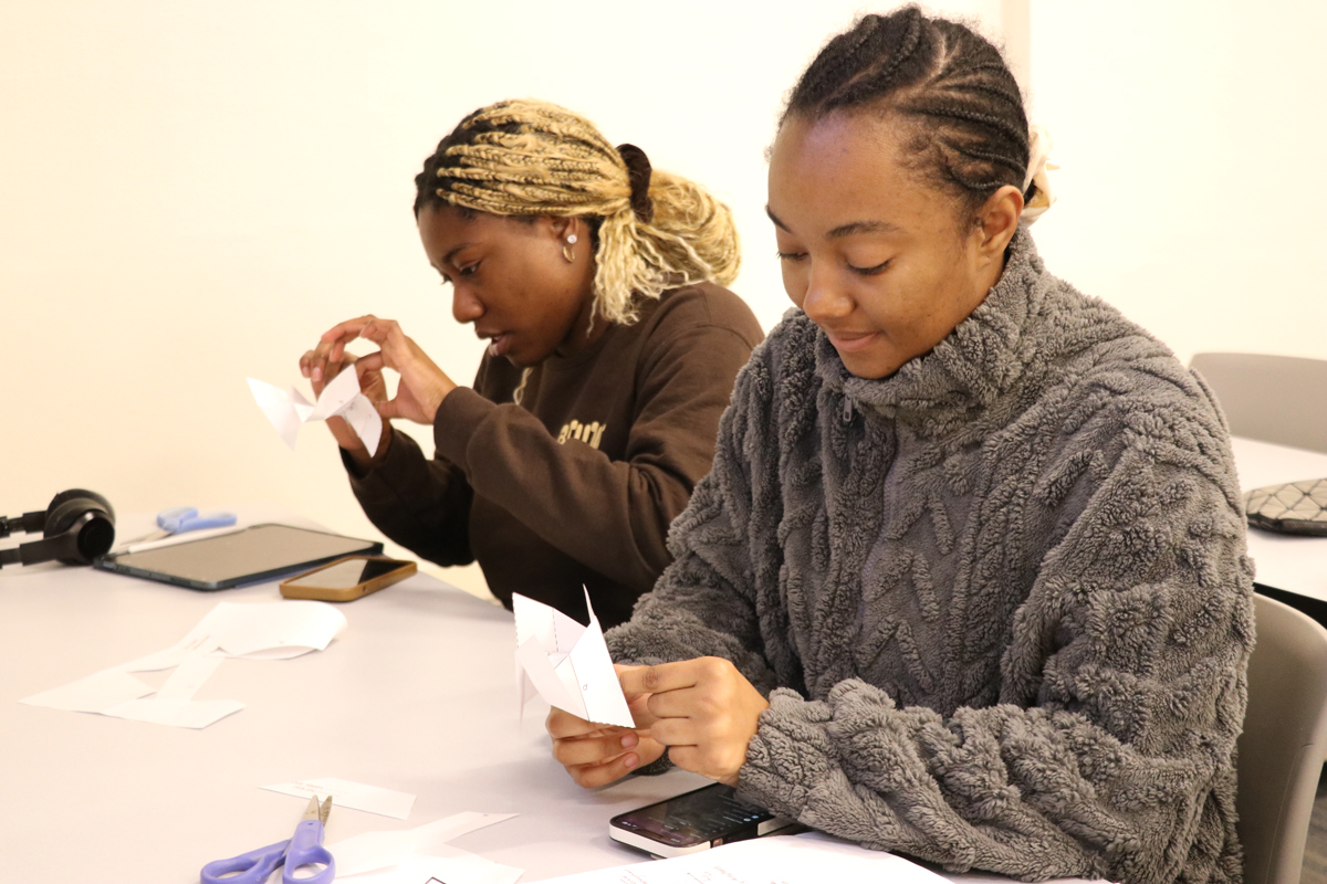 two students working on origami project in class