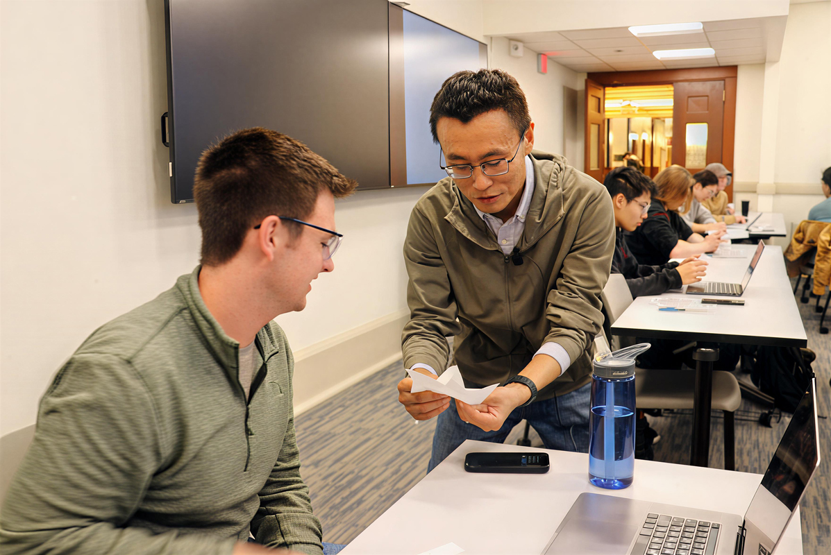 Ning assists Joey Tindall in class