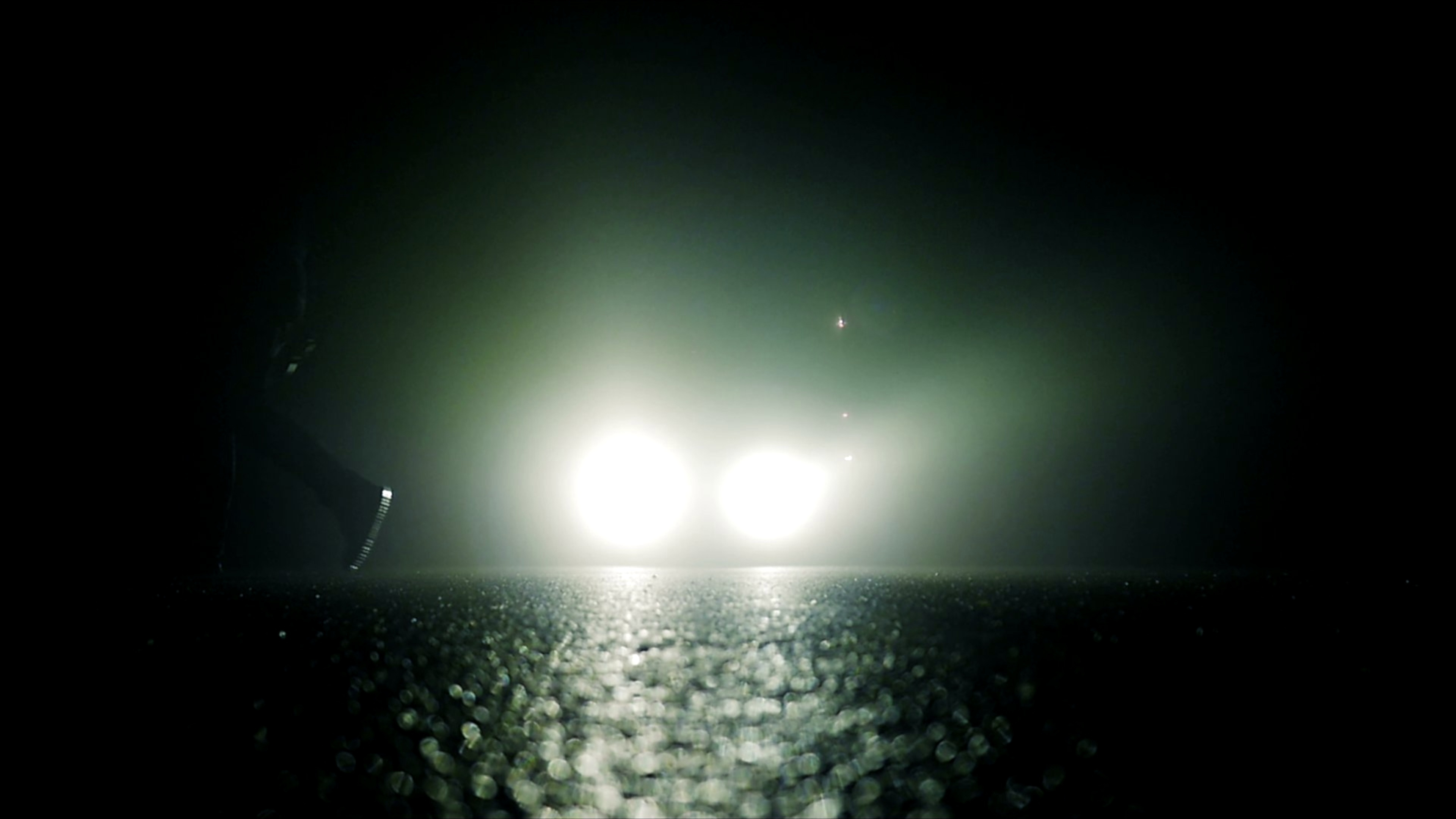 blinding car headlights on a dark road