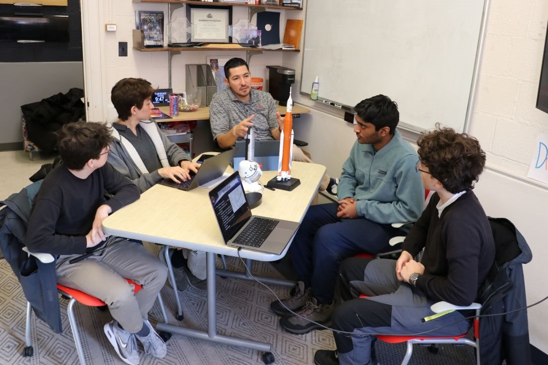 Joseph Gonzalez listens and provides feedback to members of the Electric Propulsion Team at a review. At the table are first-year students Alexander Arutchev and Toma Kanagy and second-year students Adityo Arunachalum and Sebatian Rojas Barragan.
