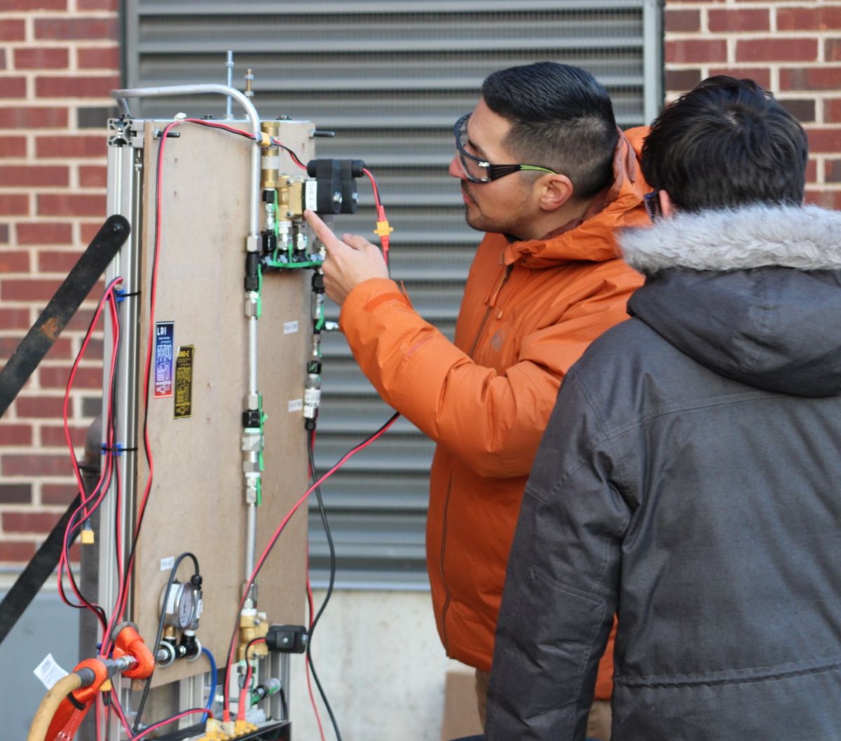 Gonzalez and graduate student JP Vranas executing test procedures during the Liquid Engine Water Flow Test to verify that the solenoid valve actuated correctly when commanded by the avionics software. The green tape strips on the hardware were added as part of the pre-test setup. This step was implemented based on lessons learned from a prior low-pressure engine injector test. The tape serves as a visual torque-verification indicator, confirming that all fittings were torqued to industry standards prior to test execution.