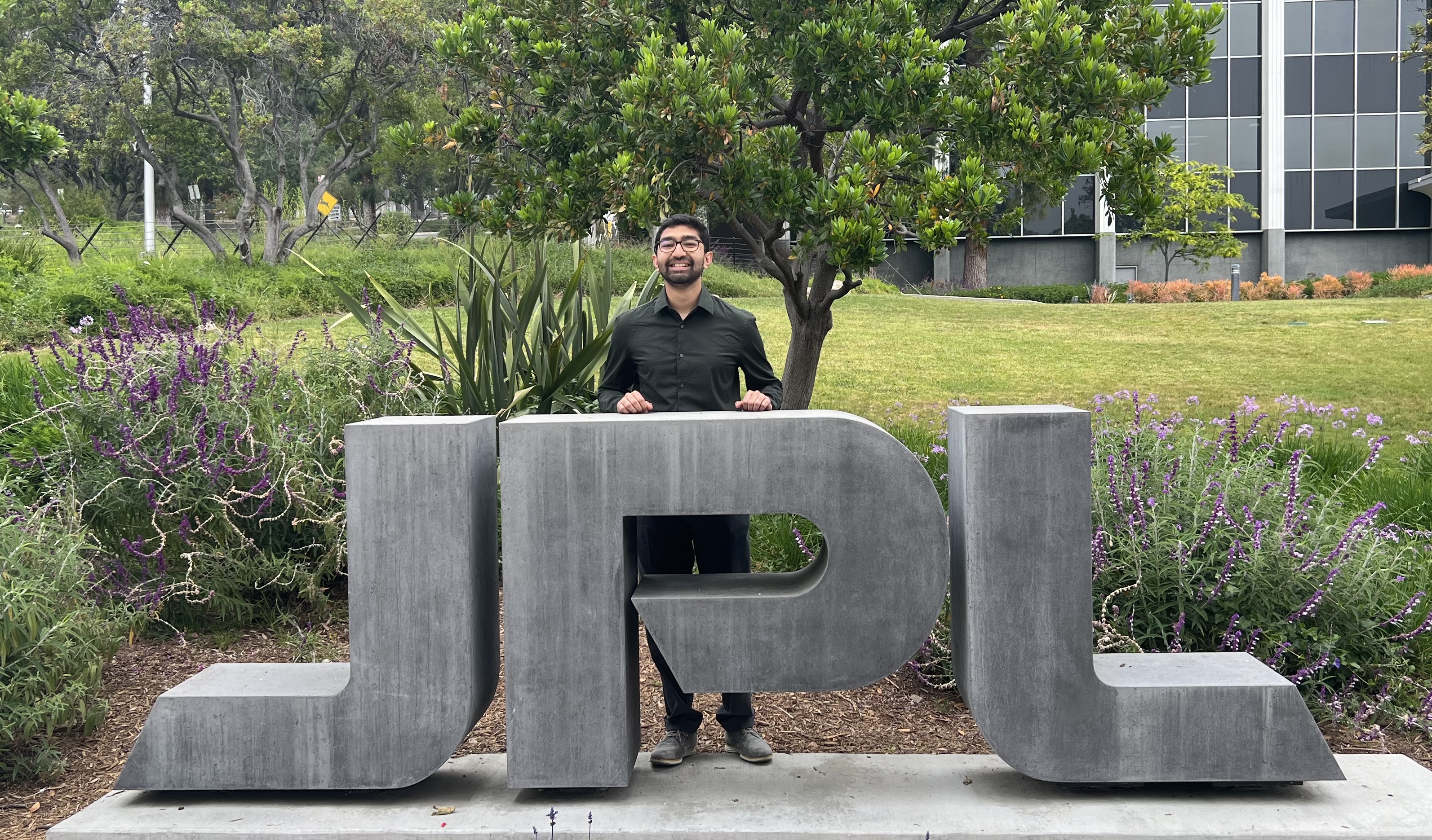 Rahil Makadia with the JPL sign