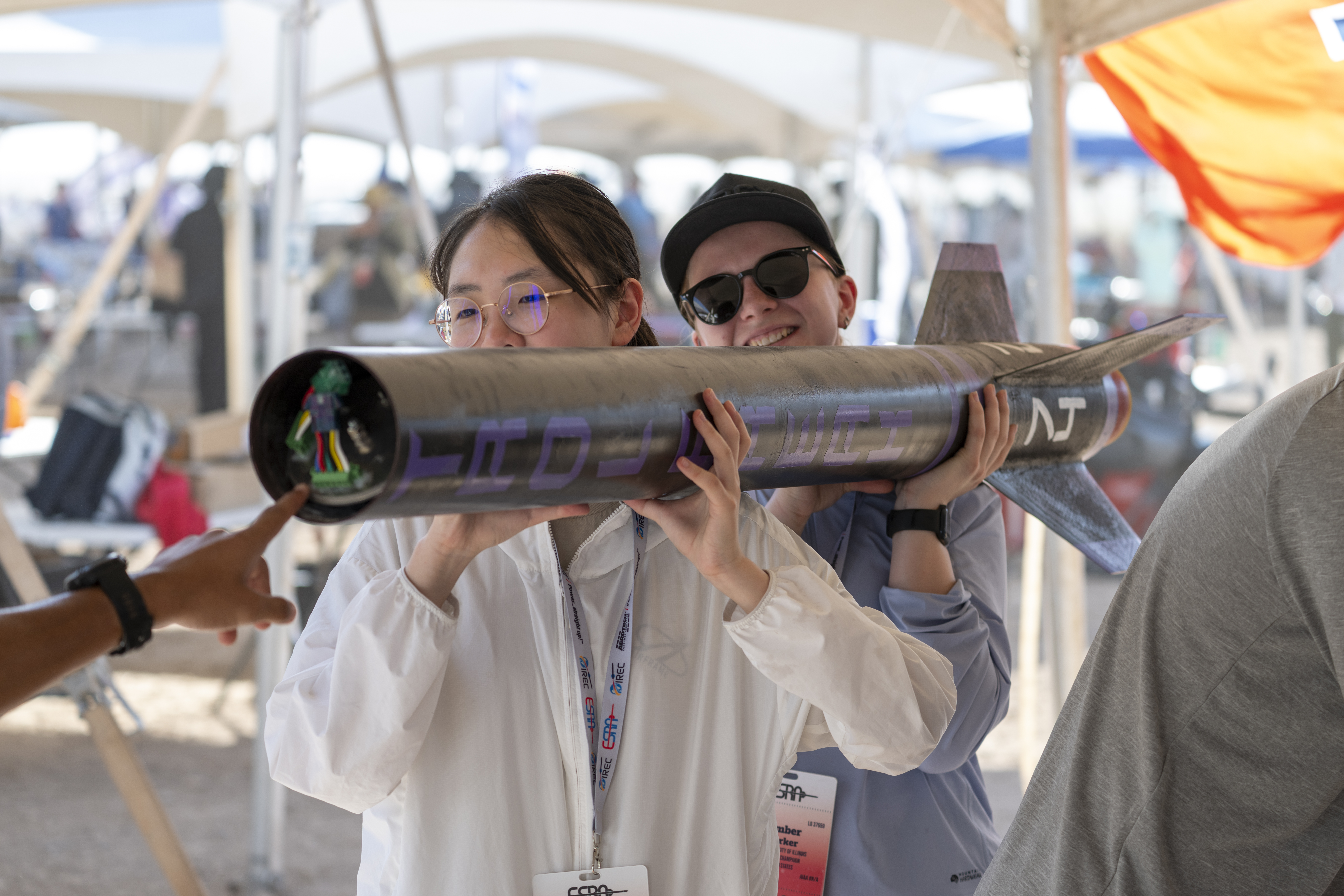 Valoria Zeng and Amber Parker carry the lower airframe to the pre-flight check-in.
