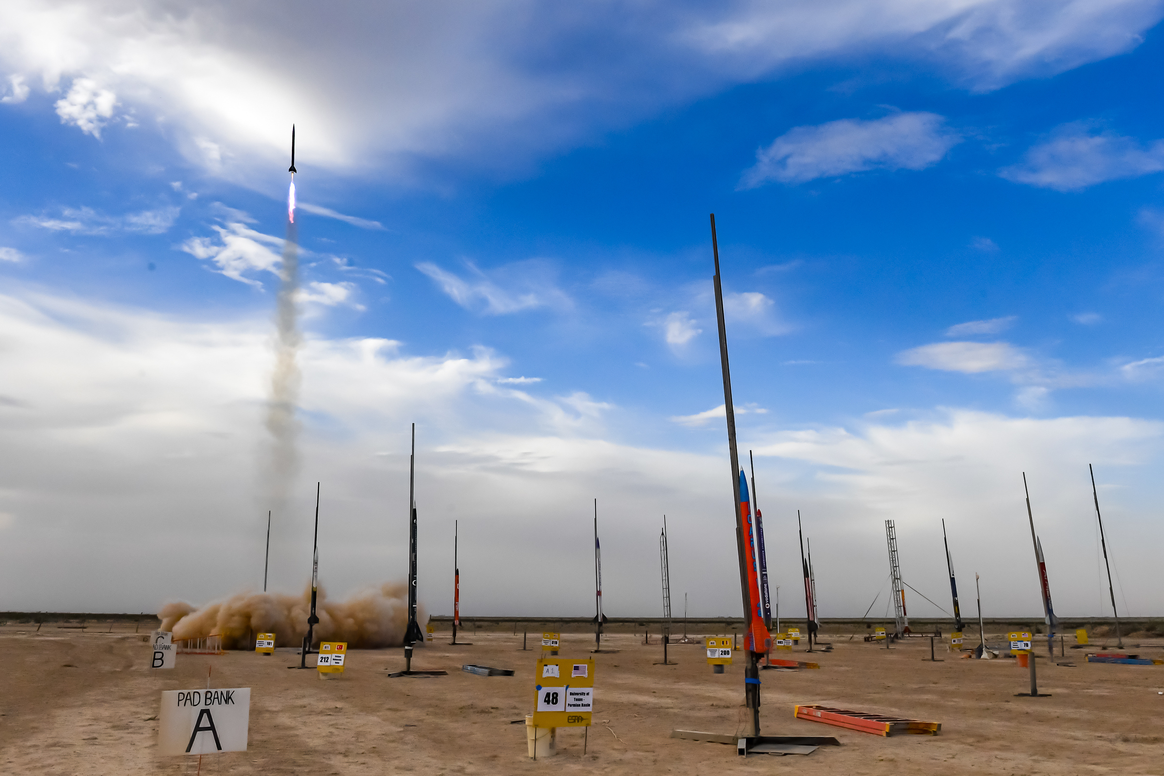 Control Freak launches, wideshot showing other rockets on the launchpad area.