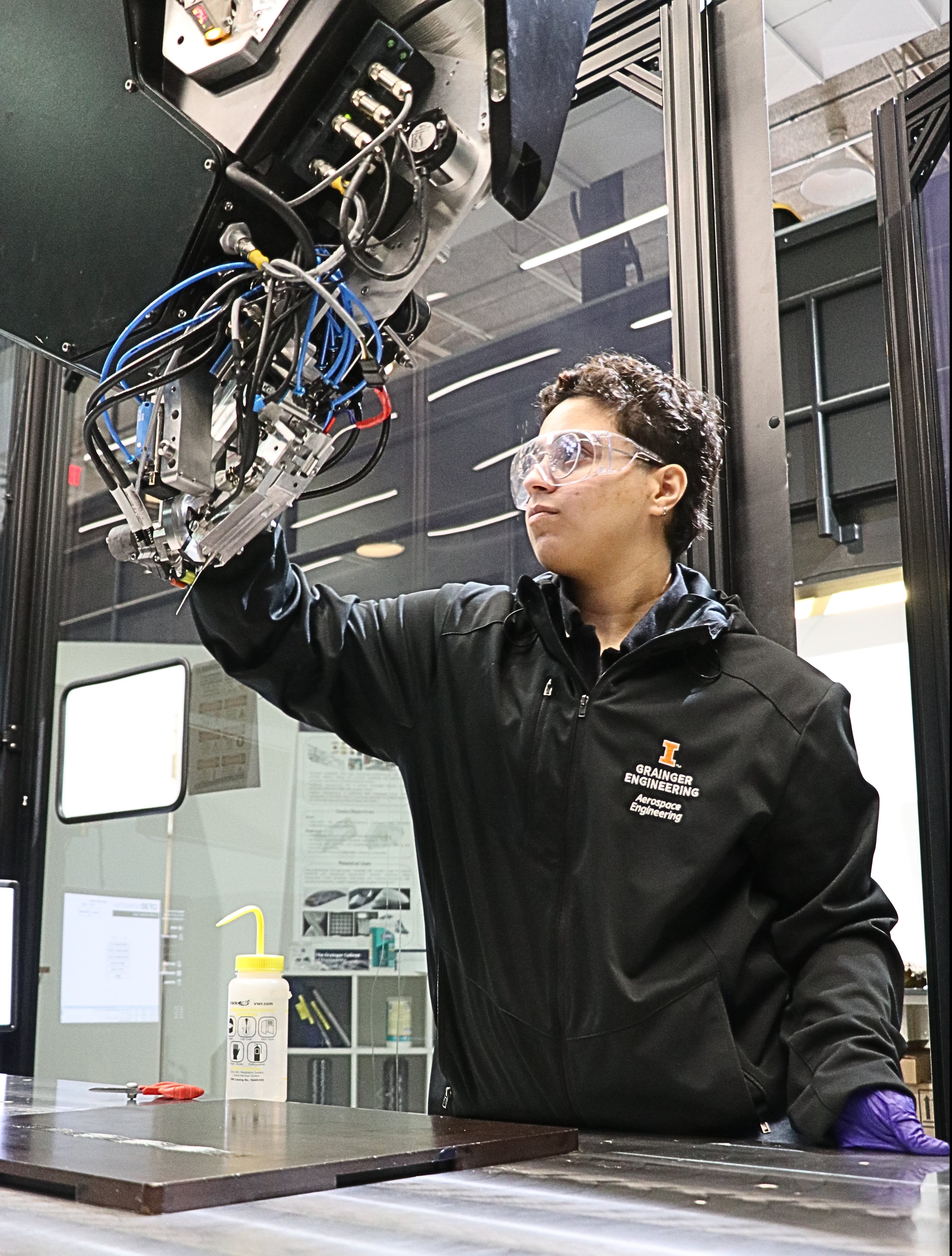 Aljawan Abdulrahim cleaning the Continuous Fiber 3D printer in the additive manufacturing lab.