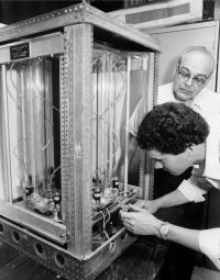 Prof. Roger A. Strehlow observes as graduate students Kurt Noe inserts an igniter into a combustion experiment apparatus. (1984)