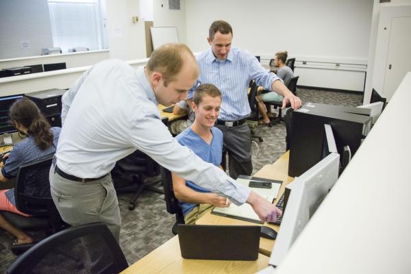 faculty helping students in lab