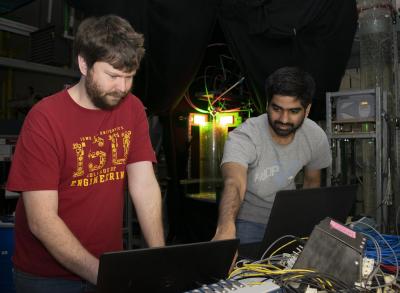  Tim Morgan (left), postdoctoral research associate in the Experimental Multiphase Flow Lab at Iowa State University, works alongside U of I AE doctoral student Palash Sashittal, to analyze high-speed imaging results. In the background is the coaxial spray test bed set up for two-view high-speed shadowgraphy