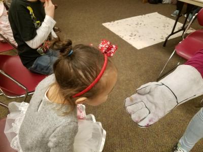 Audience member examines a penny that cracked after being exposed to liquid nitrogen at an Illinois Space Society presentation at Urbana Free Library.