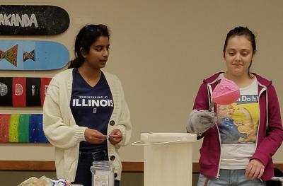 Shivani Ganesh, left, watches as Amy Exposito holds a balloon that has been submerged in liquid nitrogen.
