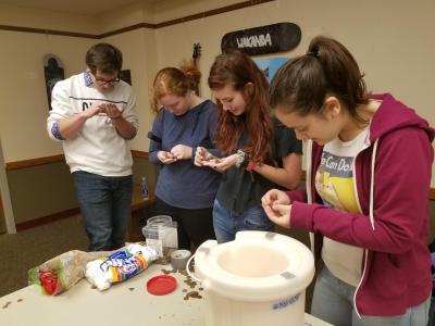 Left to right: David Robbins, Chloe Hettick, Riley Wilford, and Amy Exposito search for an older penny, made with a higher percentage of copper, to demonstrate copperâ€™s ability to withstand extreme cold.