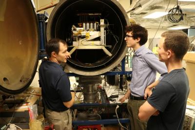 Associate Professor Joshua Rovey, left, talks about electric propulsion system testing with AE graduate students Nick Rasmont and Matt Klosterman