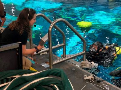 Katie Carroll, BS '19,  with diver at the NASA Neutral Buoyancy Lab pool
