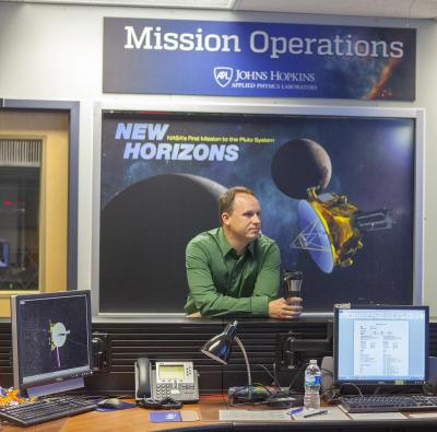 Gabe Rogers with a scale model of the New Horizons spacecraft.