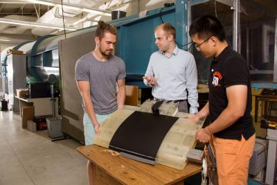 Doctoral student Aaron Perry, Assistant Professor Philip Ansell, and former masterâ€™s student Je Won Hong discuss the construction of the airfoil model with overwing ducted fans.