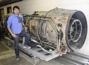 Elijah Chen, IAO president, shows off AE's Rolls Royce Concorde engine.