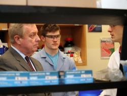 Student researchers in the lab of Scott White and Nancy Sottos brief Sen. Durbin on their individual projects in self-healing materials. 