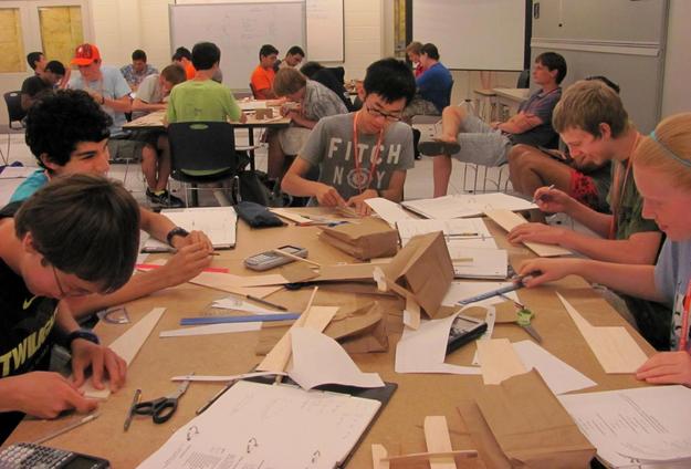 High School campers put planes together in a workshop.