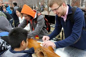 Student Aircraft Builders help visitors build toy airplanes.