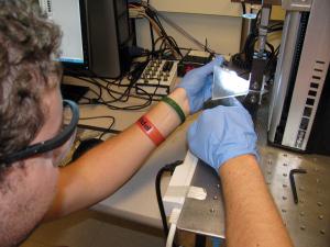 Tony Griffin, an undergraduate in Materials Science &amp; Engineering, checks the crack propagation in a loaded TDCB (Tapered Double Cantilever Beam) specimen.