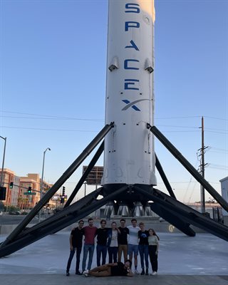Erika Jarosch and friends pose at the base of revolutionary Falcon 9 booster, August 2021 at SpaceX headquarters in Hawthorne, California