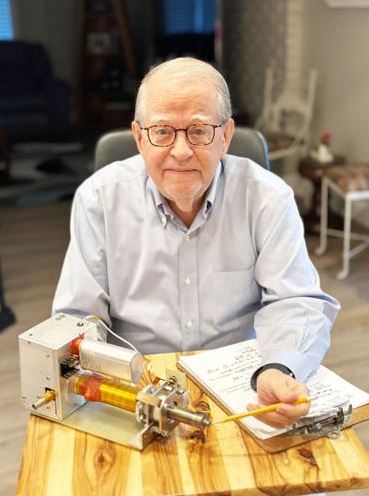 Rod Burton points to the nozzle of an electric rocket thruster at his home.