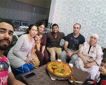 Rajeev, center in brown plaid shirt, with his Moroccan host family