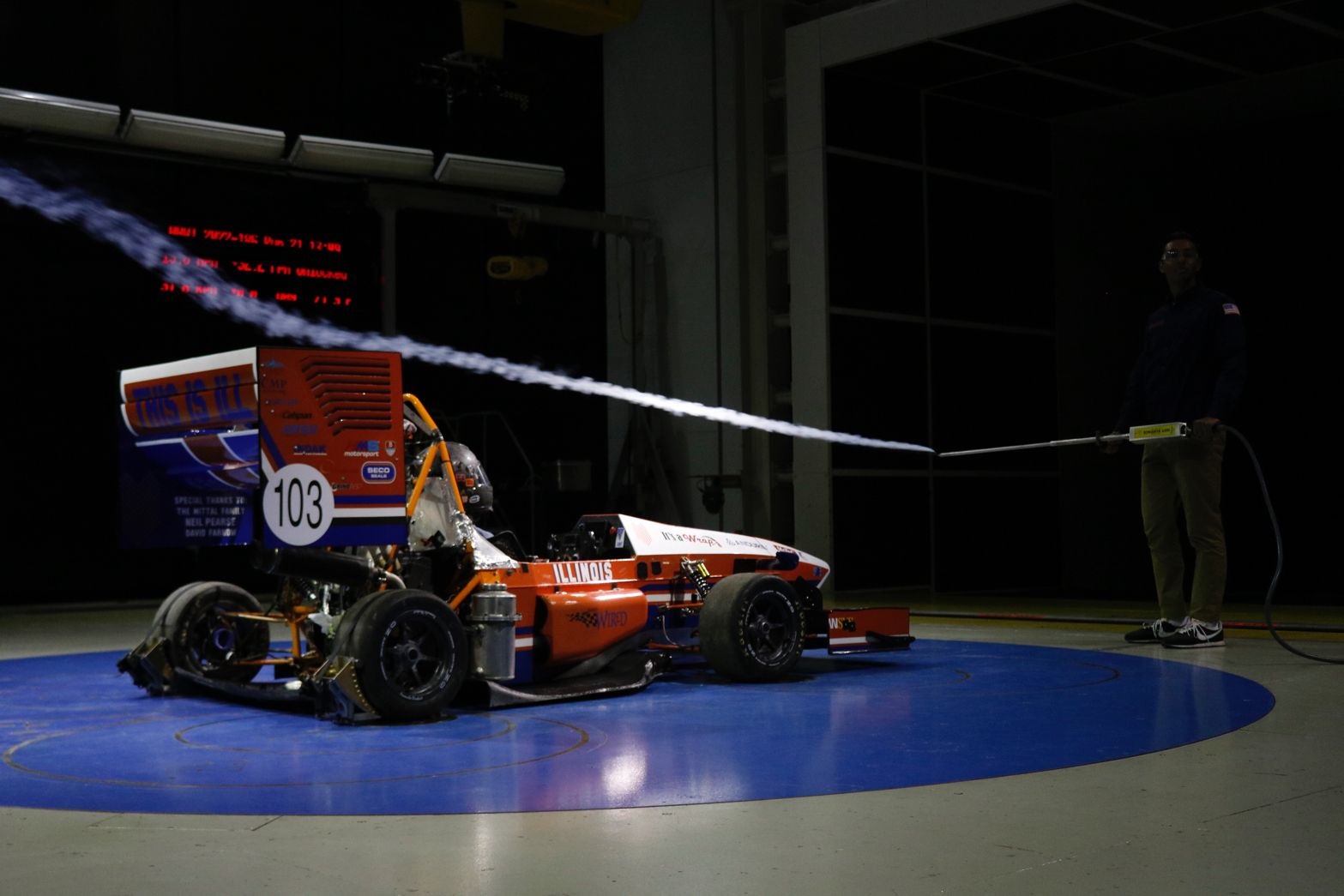 Sid Sudhir holding a smoke machine and to create a smoke trace to help visualize the flow over different surfaces of the car. Credit: Sam Lee