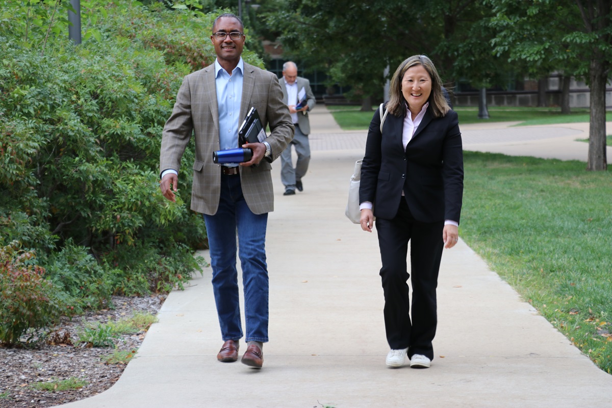Derek Smith walking with fellow alumni board member Suzy Hyun, B.S. &lsquo;00 at the end of the day of meetings on campus.