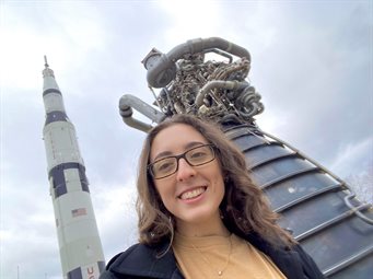 At the US Space and Rocket Center, McBride posed with a Saturn V rocket and an RS-25 engine.