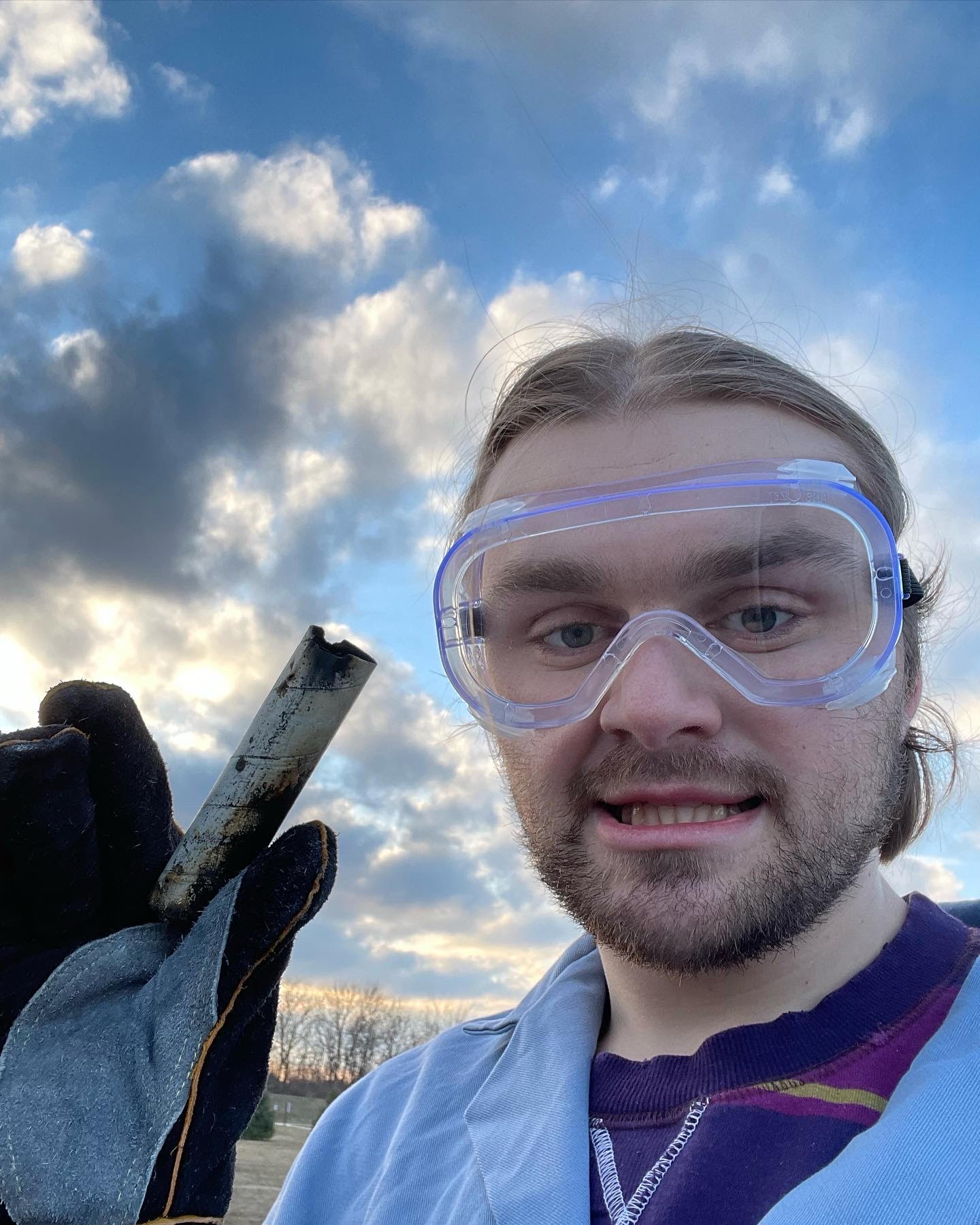 Luke O'Donnell holding a burnt solid rocket motor during his time as Safety and Logistics Officer for the Illinois Space Society solid propulsion team.