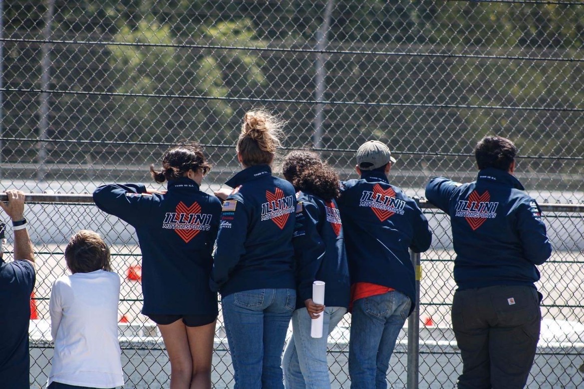 Tatiana Michel Villalobos with Illini Motorsports team members watching their car in autocross.