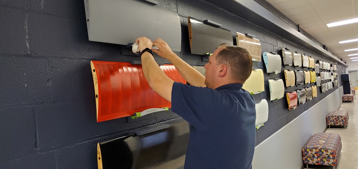 Jason Merret affixes a profile to a mount under one of the 48 airfoils on display in Talbot.