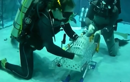 Diver testing the Illinois tool carrier underwater at the Neutral Buoyancy Lab in Houston.